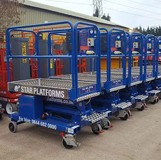 A photo showing at least five blue scissor lifts parked next to each other outside at the Reading depot